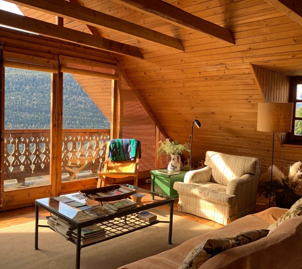 Zona común con sofás y terraza exterior con vistas a la montaña · Casa de alquiler vacacional en el Pirineo